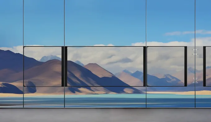 Transparent LED cabinets on a glass facade, landscape visible through the screen
